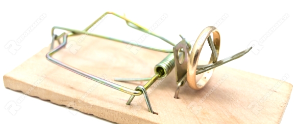 Single mousetrap with golden ring against the white background 